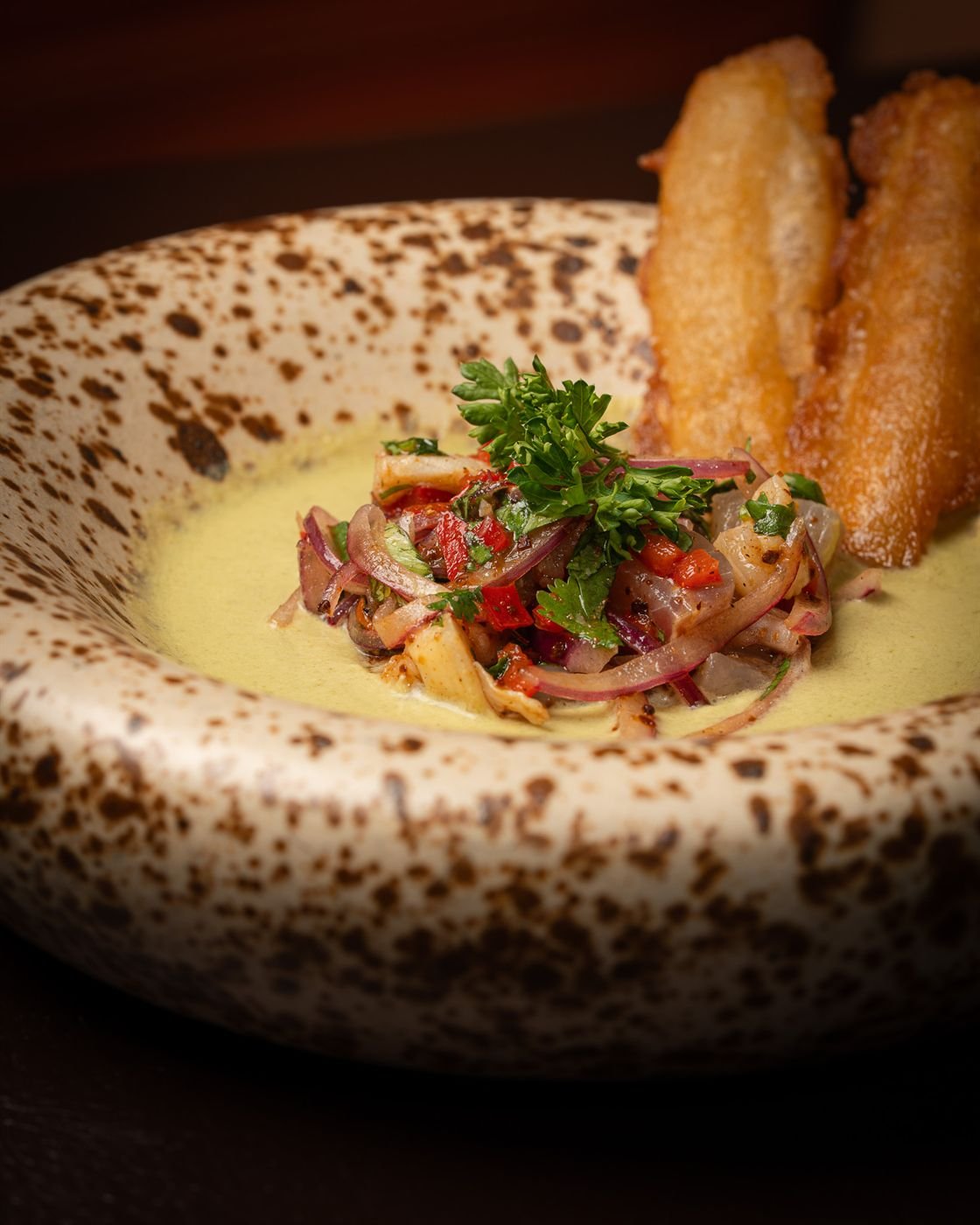 Ceviche with red onion and peppers in yellow leche de tigre, one of the Latin American small plates at La Licor